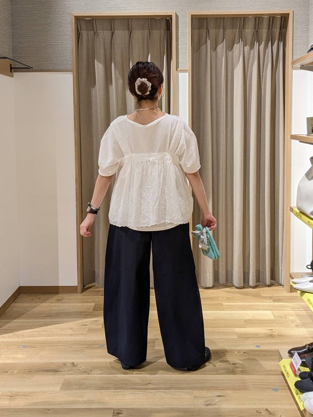 グリーン系のショルダーバッグ、グレー系のパンプス、ブルー系のその他パンツを着用したレディースの春コーディネートの2枚目の写真