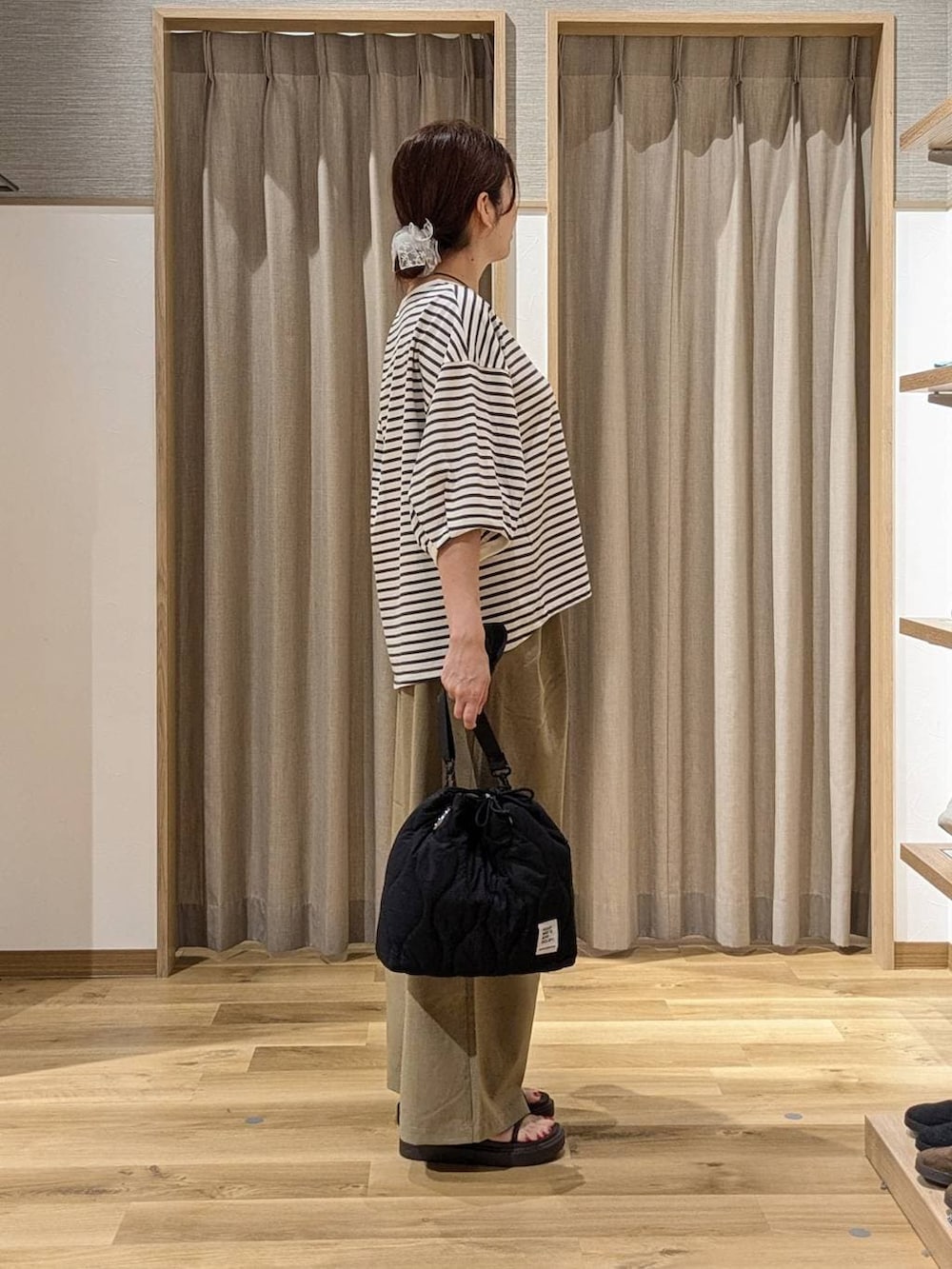 ブラック系のショルダーバッグ、ブラウン系のサンダル、ベージュ系のその他パンツを着用したレディースの夏コーディネートの2枚目の写真