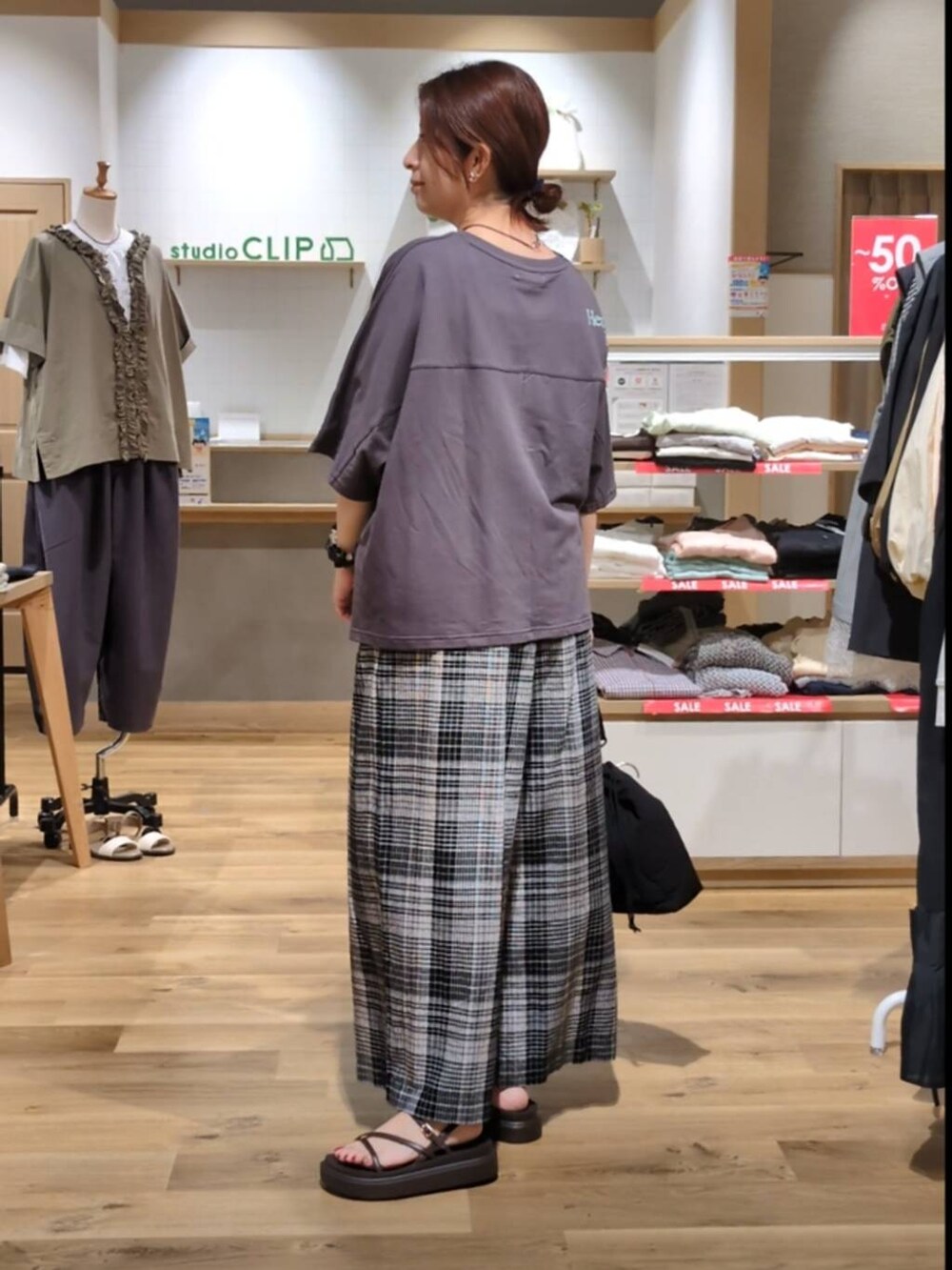 ブラック系のショルダーバッグ、ブラウン系のサンダル、ホワイト系のその他パンツを着用したレディースの夏コーディネートの2枚目の写真
