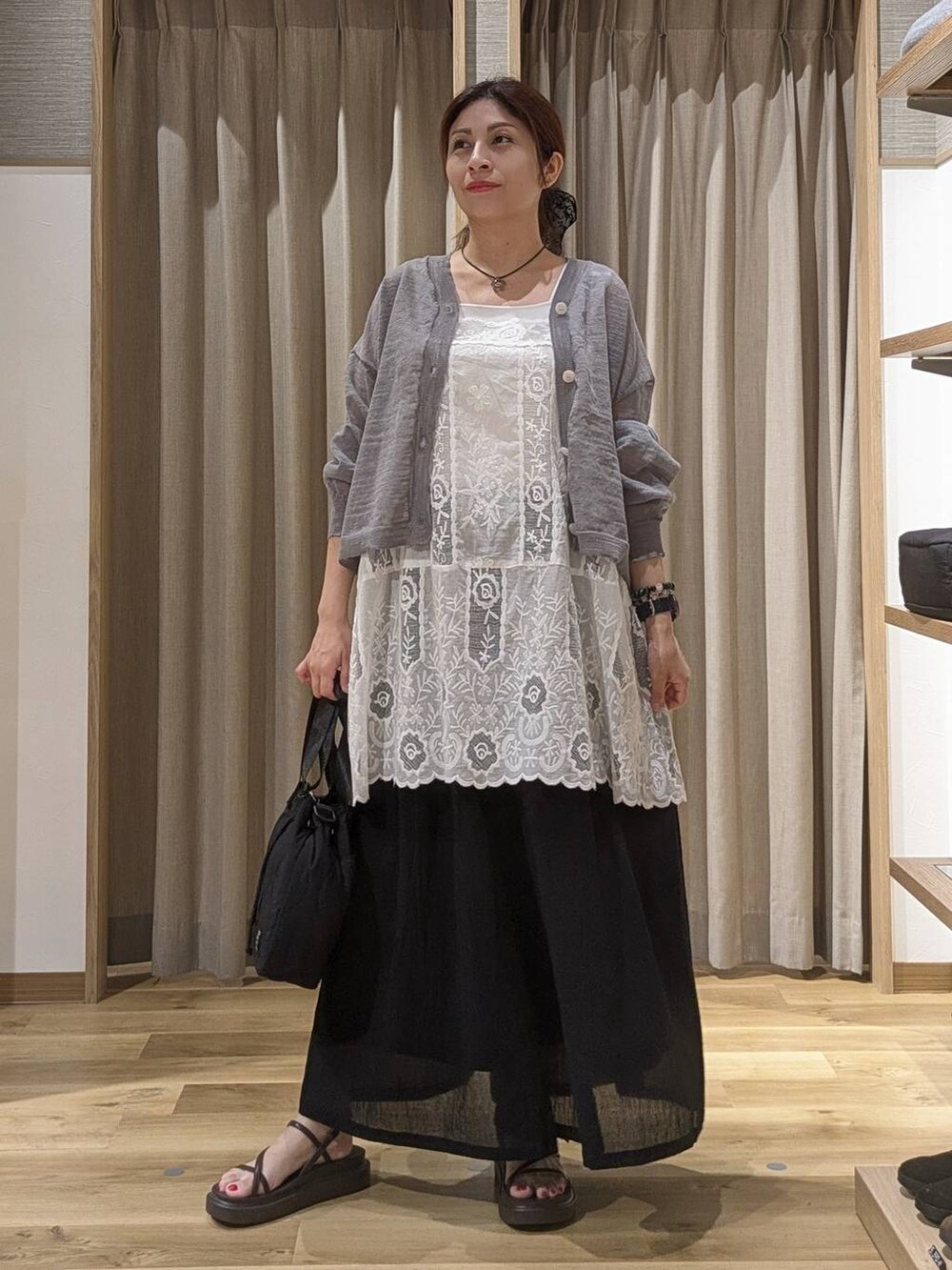 ブラック系のその他パンツ、ホワイト系のチュニック、ブラウン系のサンダルを着用したレディースの夏コーディネートの4枚目の写真