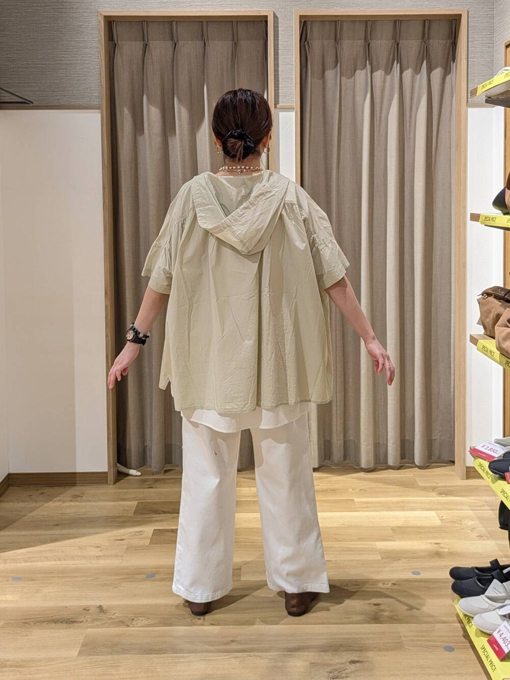 ホワイト系のデニムパンツ、ホワイト系のタンクトップ、ブラック系のシュシュを着用したレディースの春コーディネートの2枚目の写真