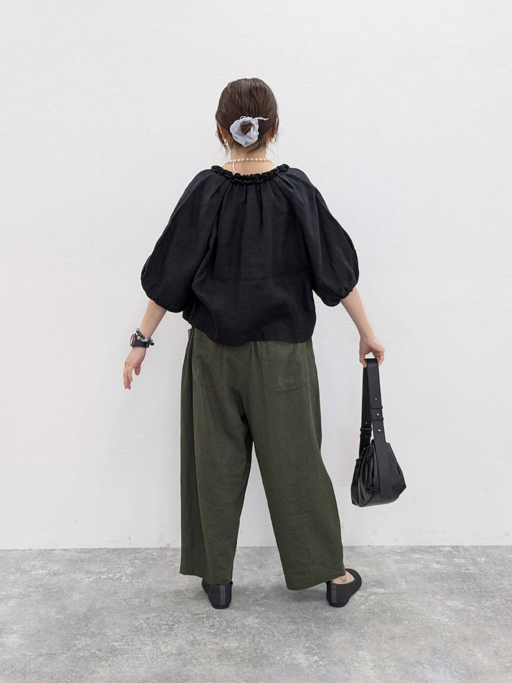 ブラック系のショルダーバッグ、グレー系のパンプス、ベージュ系のタンクトップを着用したレディースの春コーディネートの2枚目の写真