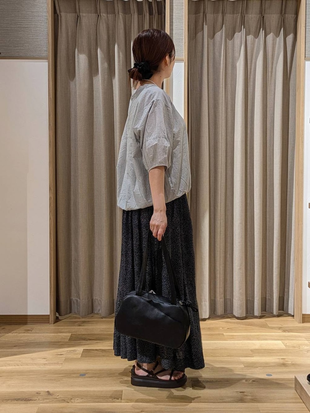 ブラック系のショルダーバッグ、グレー系のシャツ/ブラウス、ブラウン系のサンダルを着用したレディースの夏コーディネートの2枚目の写真