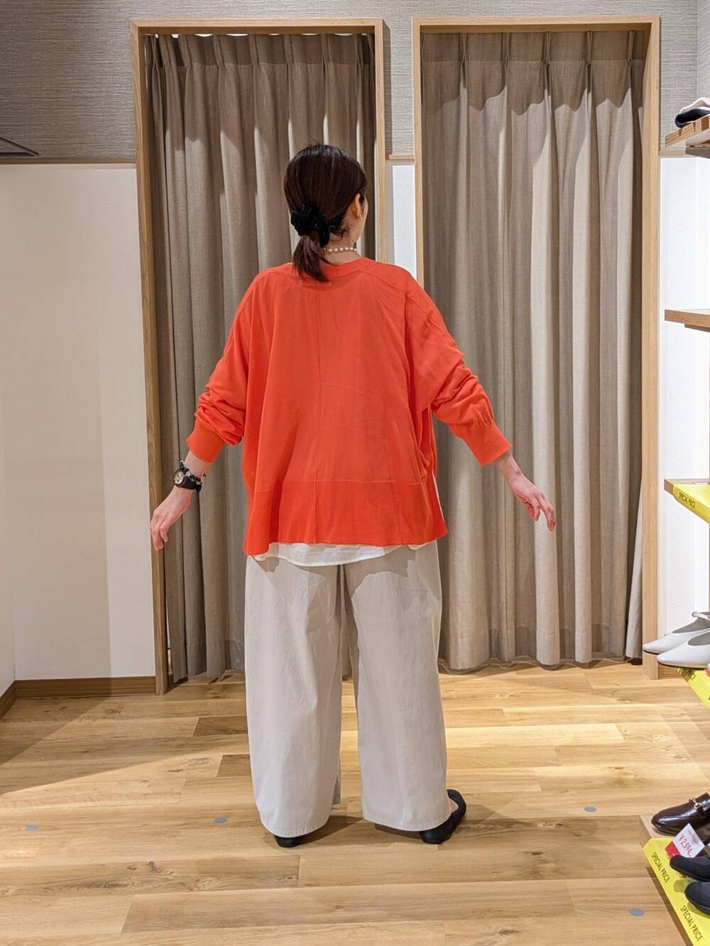 オレンジ系のカーディガン/ボレロ、ホワイト系のシャツ/ブラウス、グレー系のパンプスを着用したレディースの春コーディネートの2枚目の写真