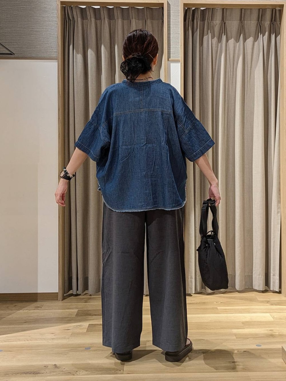 ブラック系のベスト、ブラウン系のサンダル、グレー系のその他パンツを着用したレディースの夏コーディネートの3枚目の写真