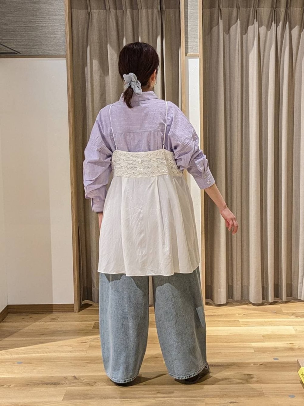 ブルー系のデニムパンツ、ブラウン系のショルダーバッグ、ブラウン系のローファーを着用したレディースの冬コーディネートの2枚目の写真