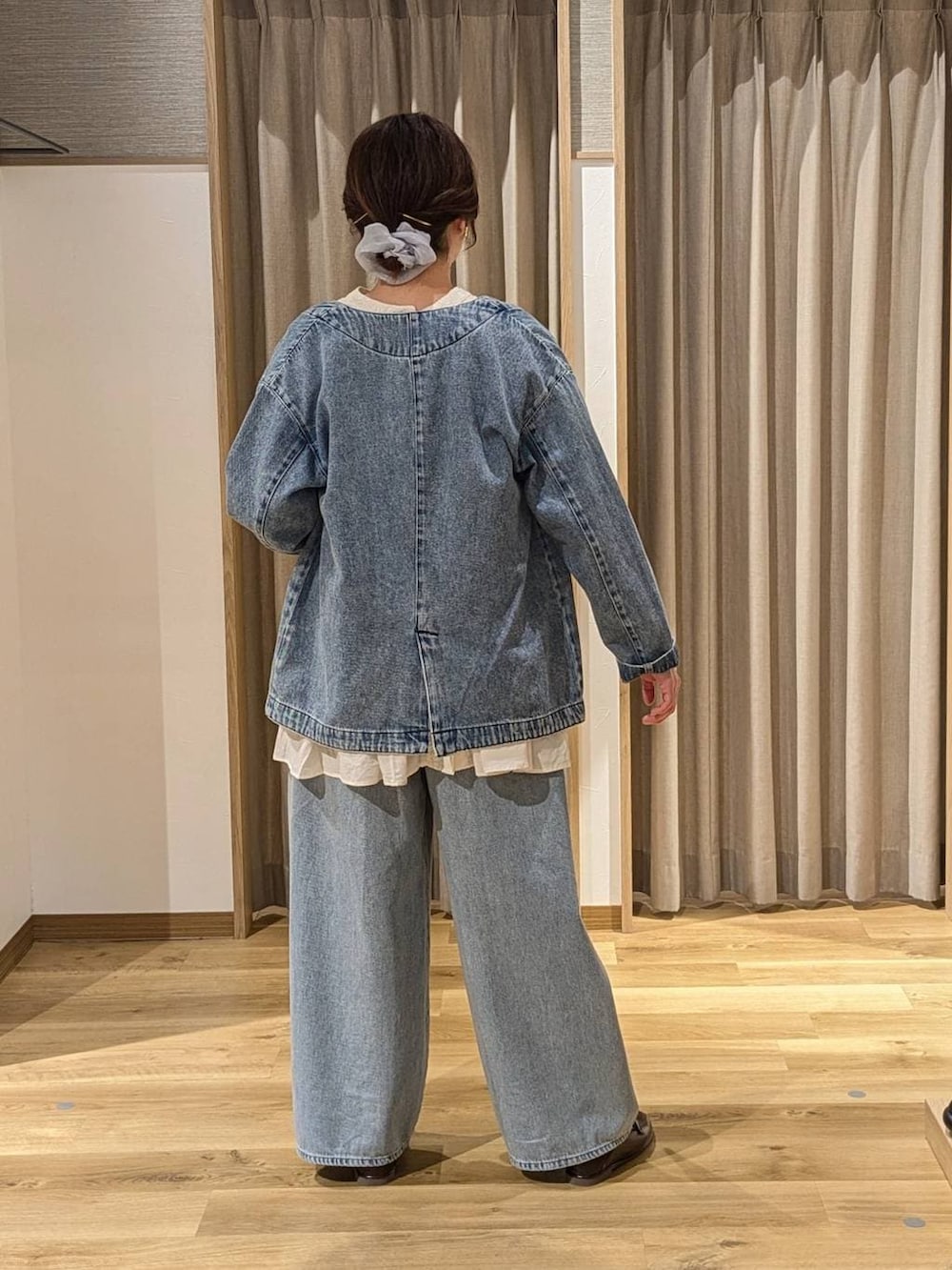 ブルー系のデニムパンツ、ブラウン系のショルダーバッグ、ホワイト系のシャツ/ブラウスを着用したレディースの冬コーディネートの3枚目の写真