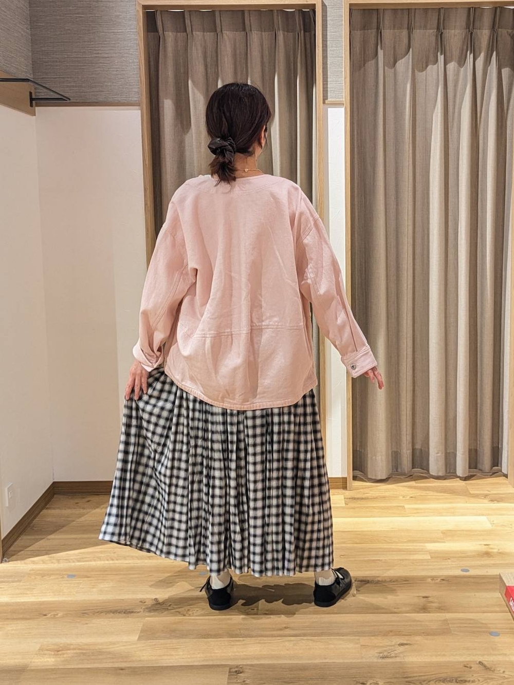 ピンク系のノーカラージャケット、ブラック系のスニーカー、ホワイト系のTシャツ/カットソーを着用したレディースの冬コーディネートの2枚目の写真