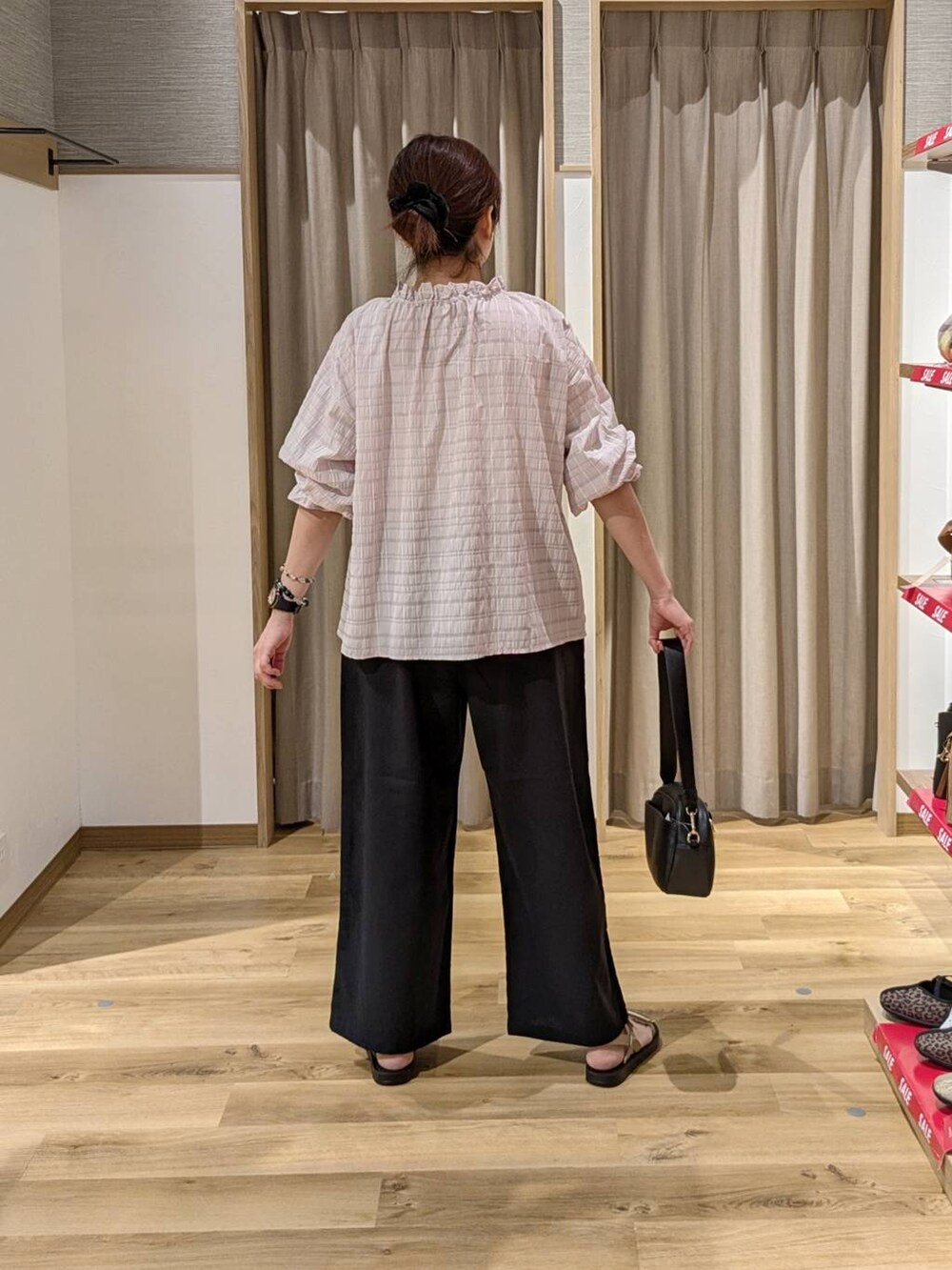 ブラック系のショルダーバッグ、ゴールド系のサンダル、ブラック系のその他パンツを着用したレディースの夏コーディネートの2枚目の写真