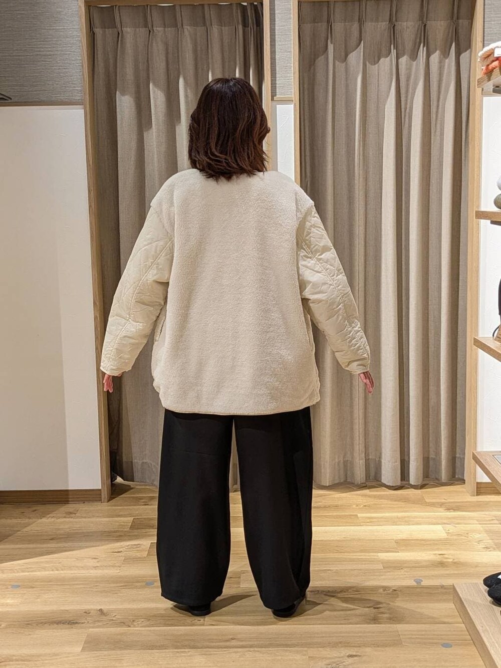 ホワイト系のブルゾン、ホワイト系のTシャツ/カットソー、ブラック系のその他パンツを着用したレディースの冬コーディネートの2枚目の写真