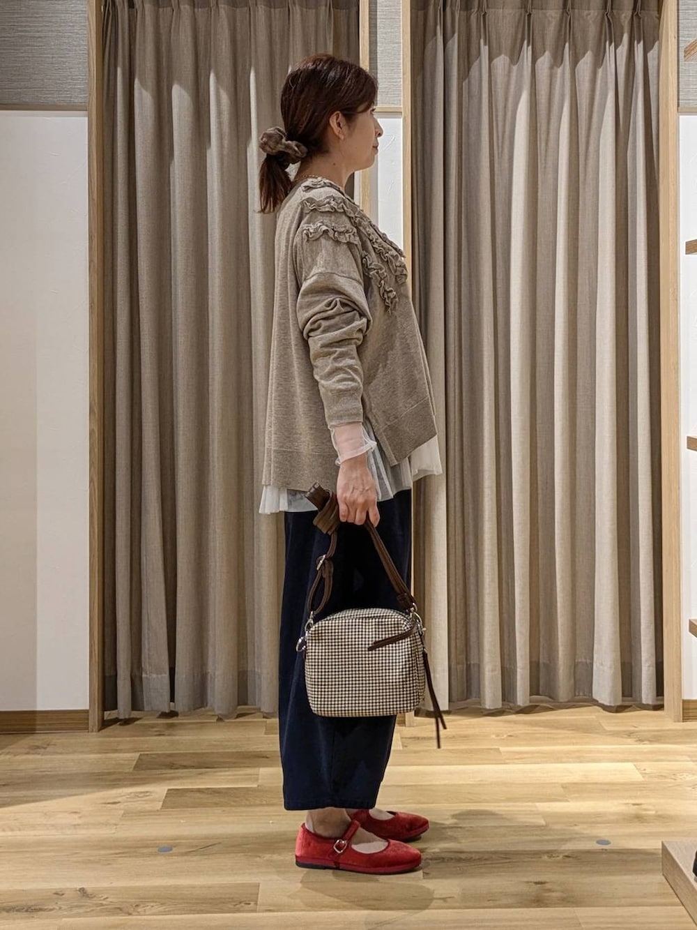 レッド系のその他シューズ、その他のTシャツ/カットソー、ベージュ系のカーディガン/ボレロを着用したレディースの秋コーディネートの2枚目の写真