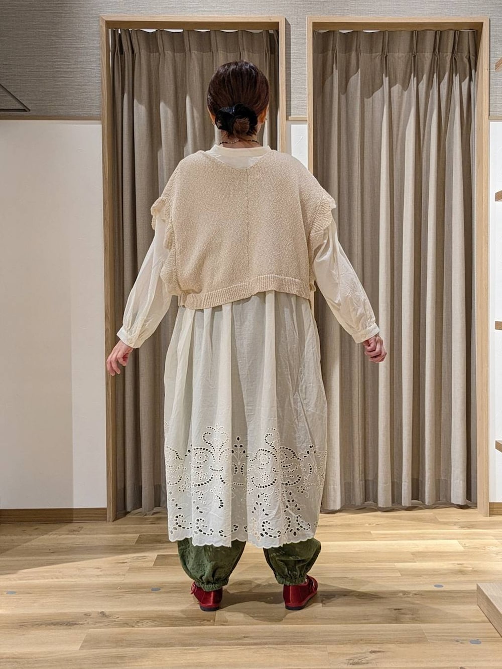 グリーン系のその他パンツ、レッド系のその他シューズ、ベージュ系のニット/セーターを着用したレディースの秋コーディネートの3枚目の写真