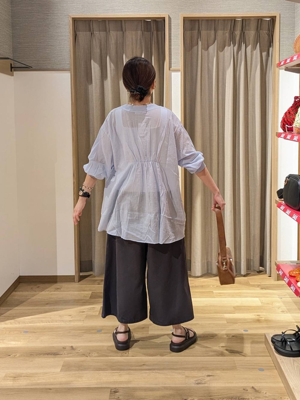 ブラウン系のショルダーバッグ、ブラウン系のサンダル、ベージュ系のタンクトップを着用したレディースの夏コーディネートの2枚目の写真