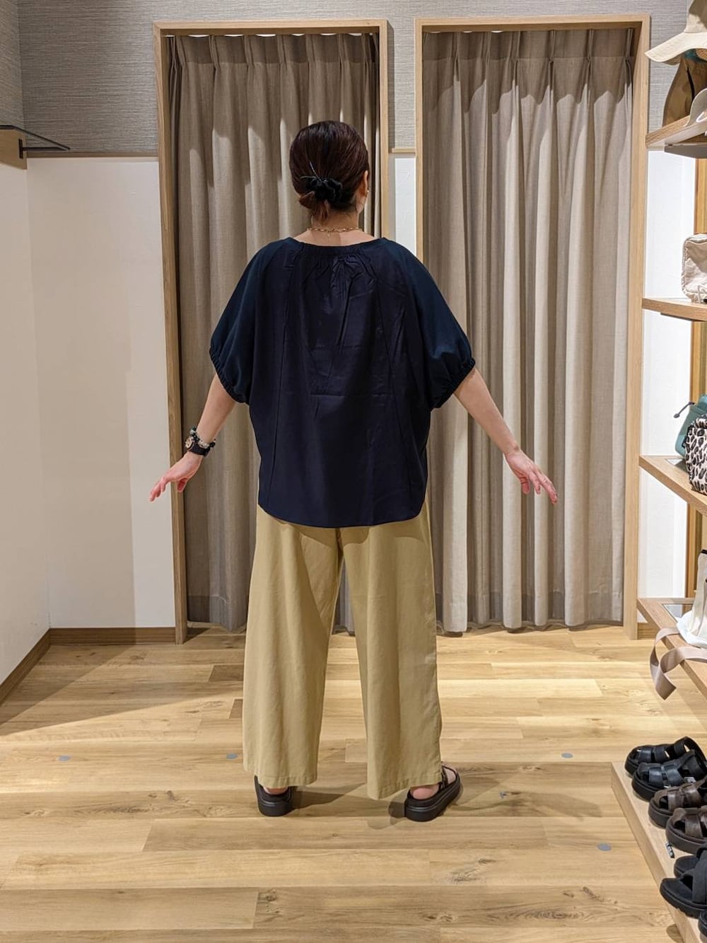 イエロー系のトートバッグ、ブラウン系のサンダル、ベージュ系のその他パンツを着用したレディースの夏コーディネートの2枚目の写真