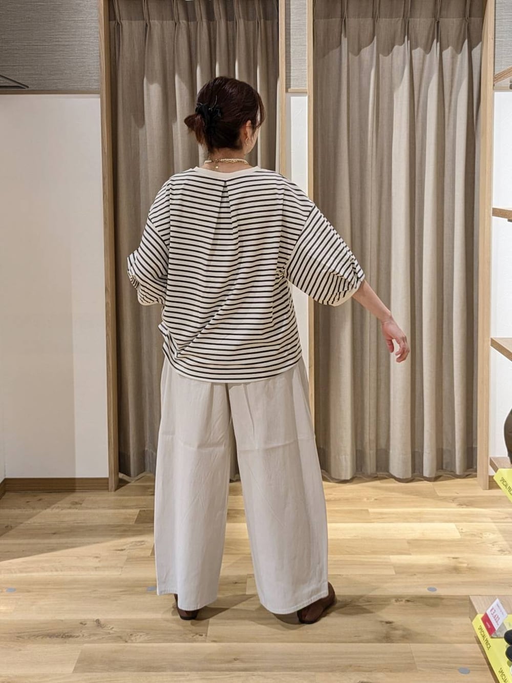 グリーン系のショルダーバッグ、ブラウン系のパンプス、その他のネックレスを着用したレディースの春コーディネートの2枚目の写真