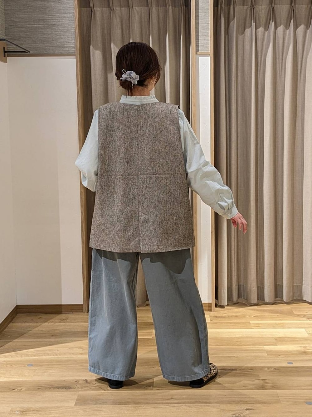 ベージュ系のベスト、ブラック系のショルダーバッグ、その他のスニーカーを着用したレディースの冬コーディネートの2枚目の写真