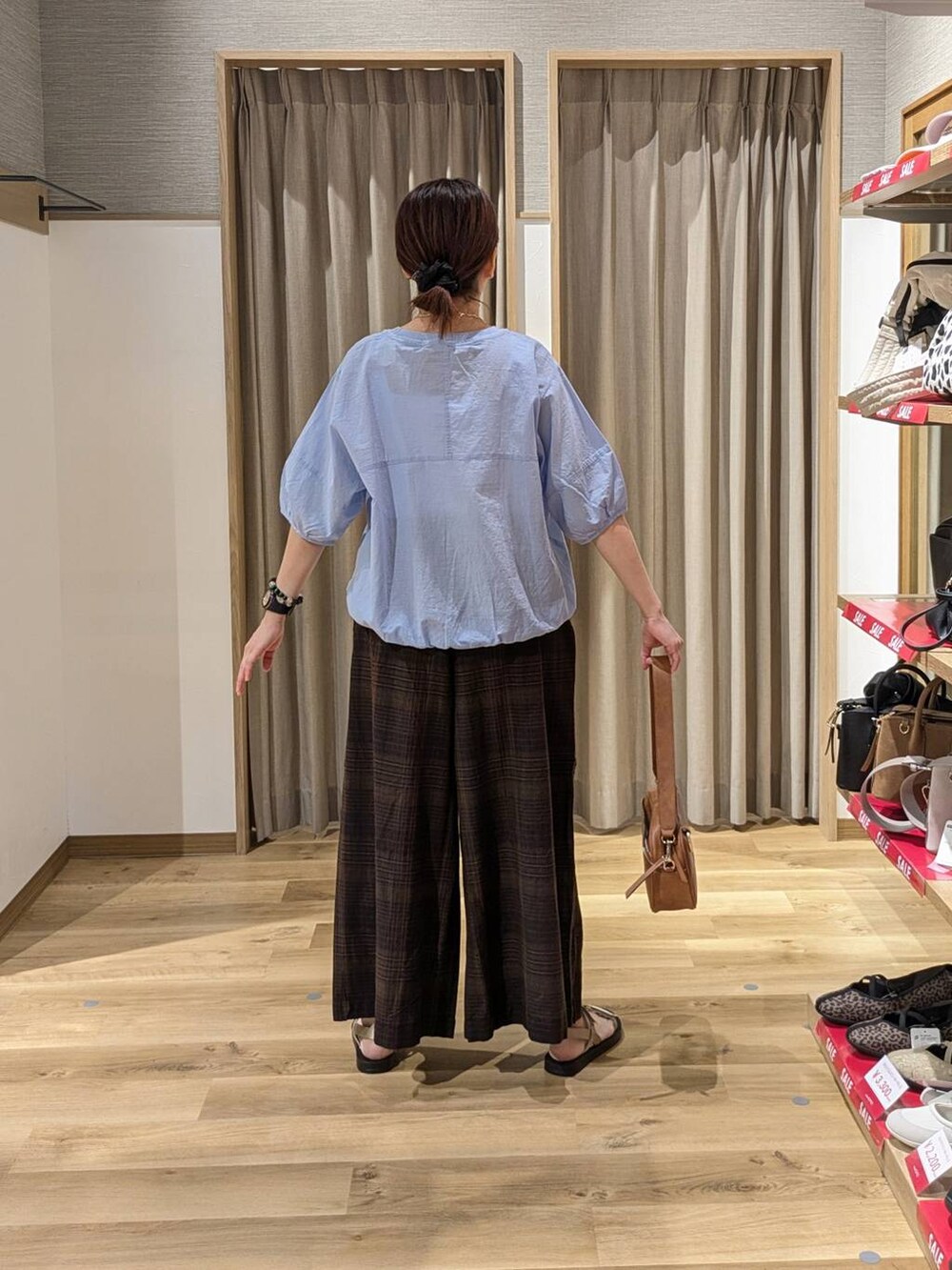 ブルー系のシャツ/ブラウス、ブラウン系のショルダーバッグ、ゴールド系のサンダルを着用したレディースの夏コーディネートの2枚目の写真