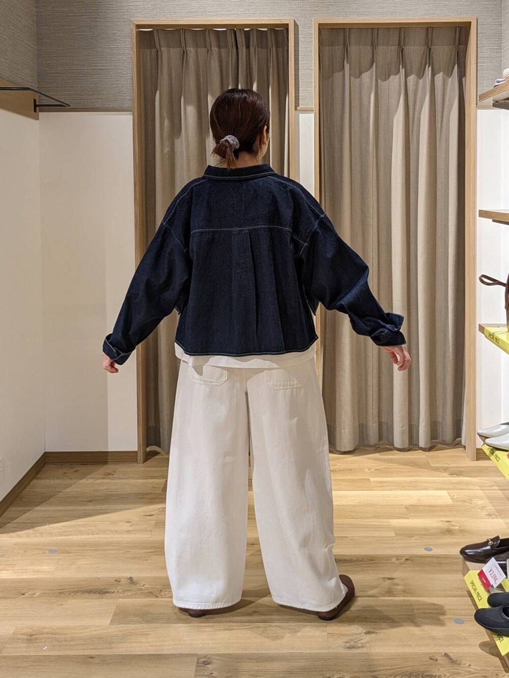 ホワイト系のデニムパンツ、ブルー系のデニムジャケット、ブラウン系のパンプスを着用したレディースの春コーディネートの2枚目の写真