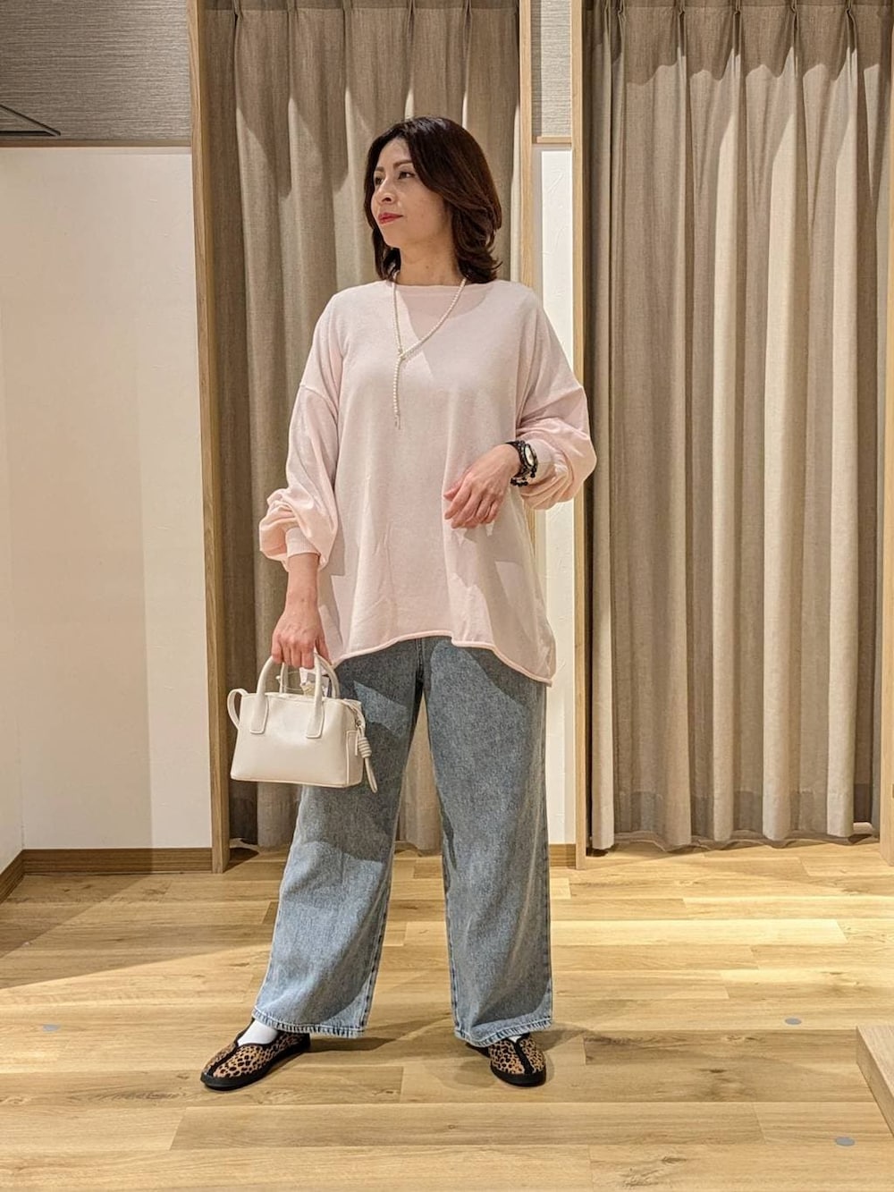 ブルー系のデニムパンツ、その他のスニーカー、ピンク系のニット/セーターを着用したレディースの冬コーディネートの2枚目の写真