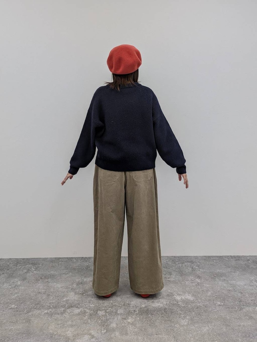 レッド系のパンプス、ブルー系のニット/セーター、ブラウン系のその他パンツを着用したレディースの冬コーディネートの2枚目の写真