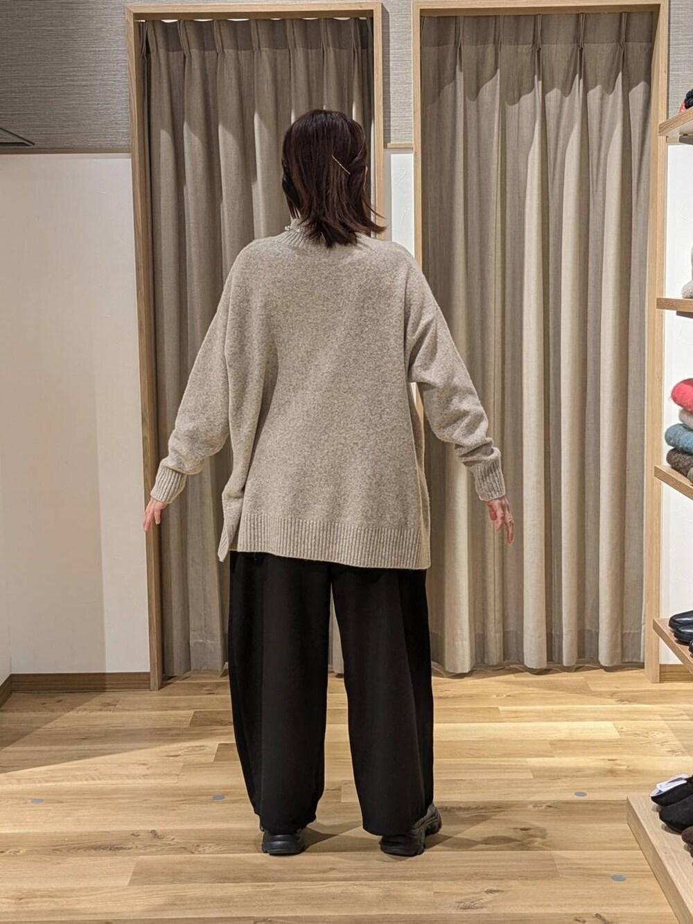 ブラック系のブーツ、ブラック系のその他パンツ、ベージュ系のニット/セーターを着用したレディースの冬コーディネートの2枚目の写真