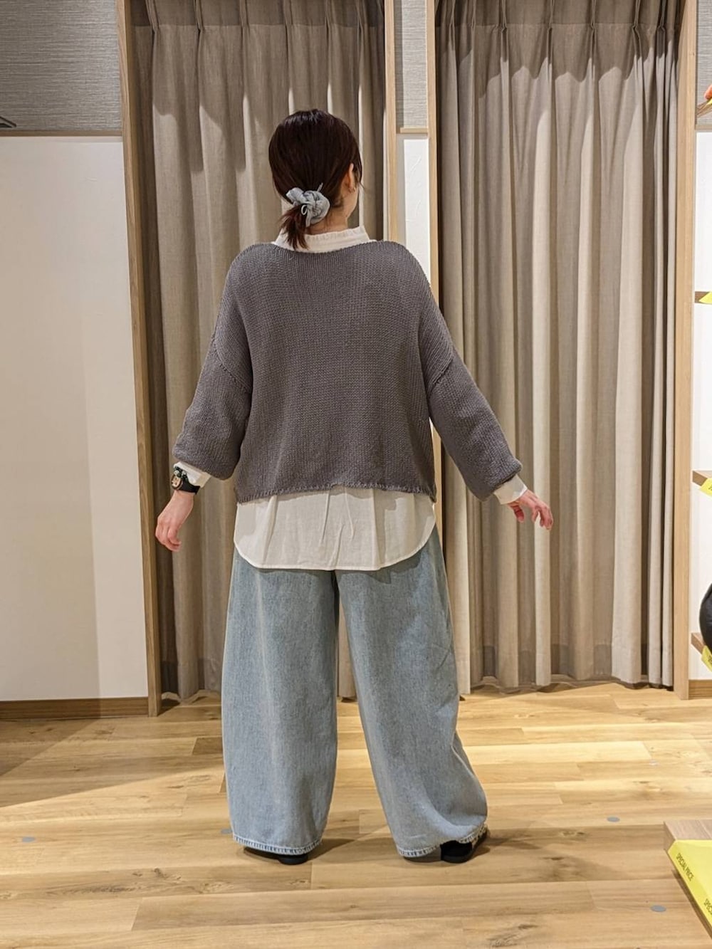 ブルー系のデニムパンツ、その他のスニーカー、オレンジ系のショルダーバッグを着用したレディースの冬コーディネートの2枚目の写真