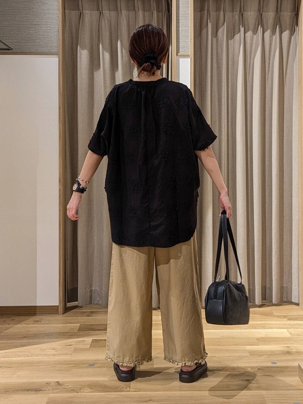 ブラック系のショルダーバッグ、ブラック系のシャツ/ブラウス、ブラウン系のサンダルを着用したレディースの夏コーディネートの3枚目の写真