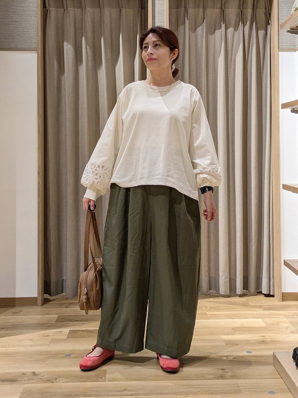 ブラウン系のショルダーバッグ、レッド系のその他シューズ、ホワイト系のTシャツ/カットソーを着用したレディースの秋コーディネートの4枚目の写真