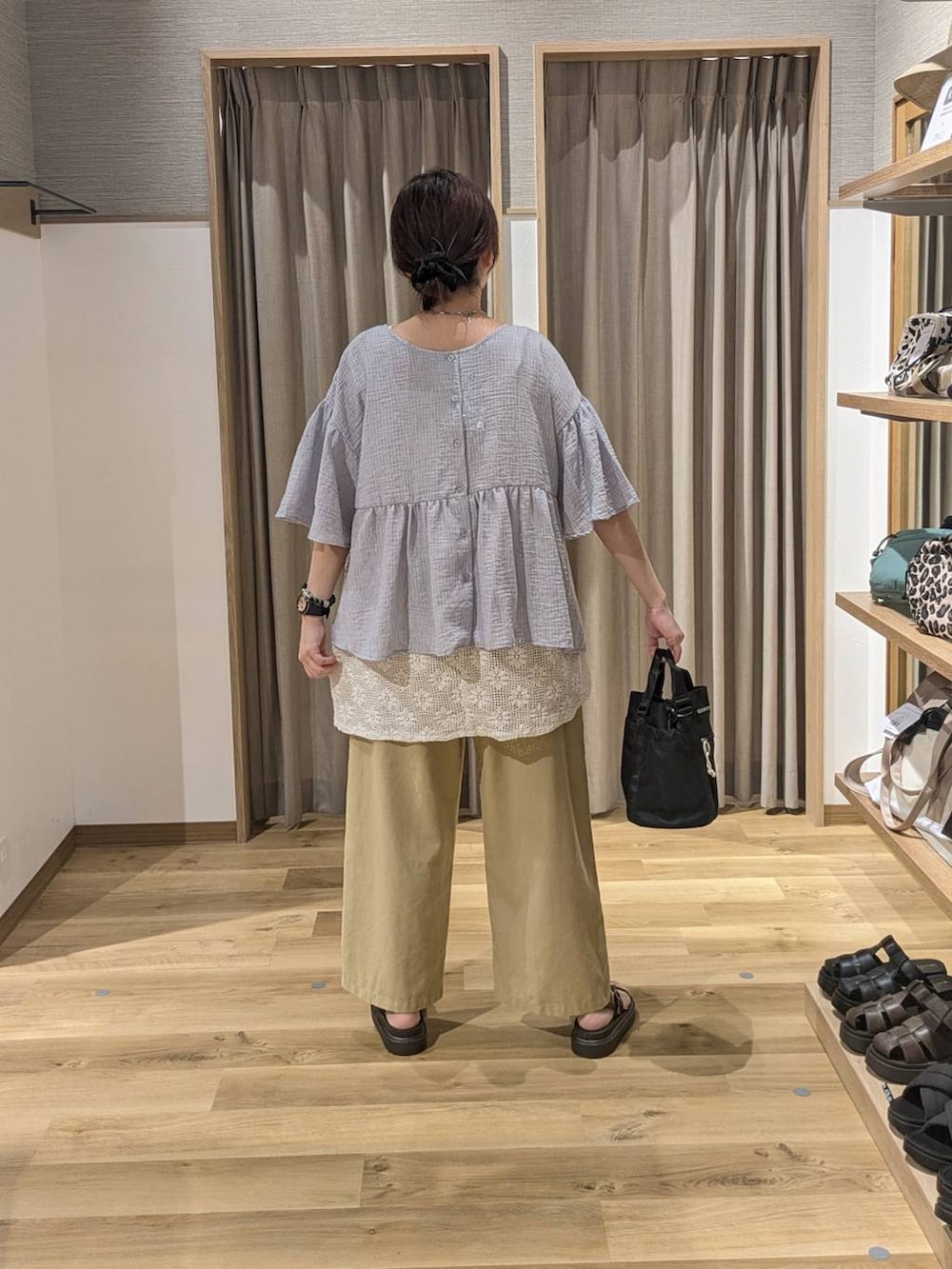 ブラウン系のサンダル、ホワイト系のベスト、ベージュ系のその他パンツを着用したレディースの夏コーディネートの2枚目の写真