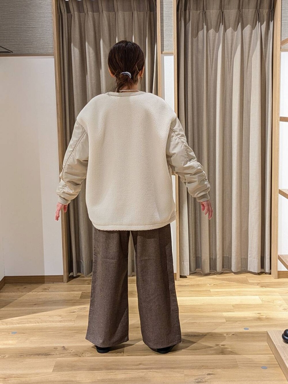 ホワイト系のその他アウター、ブラウン系のその他パンツ、ブルー系のニット/セーターを着用したレディースの冬コーディネートの2枚目の写真