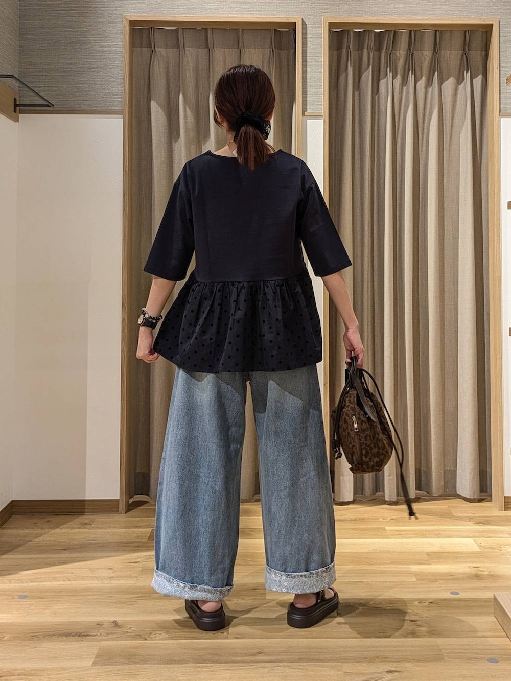 ブルー系のデニムパンツ、ブルー系のTシャツ/カットソー、ブラウン系のショルダーバッグを着用したレディースの夏コーディネートの3枚目の写真