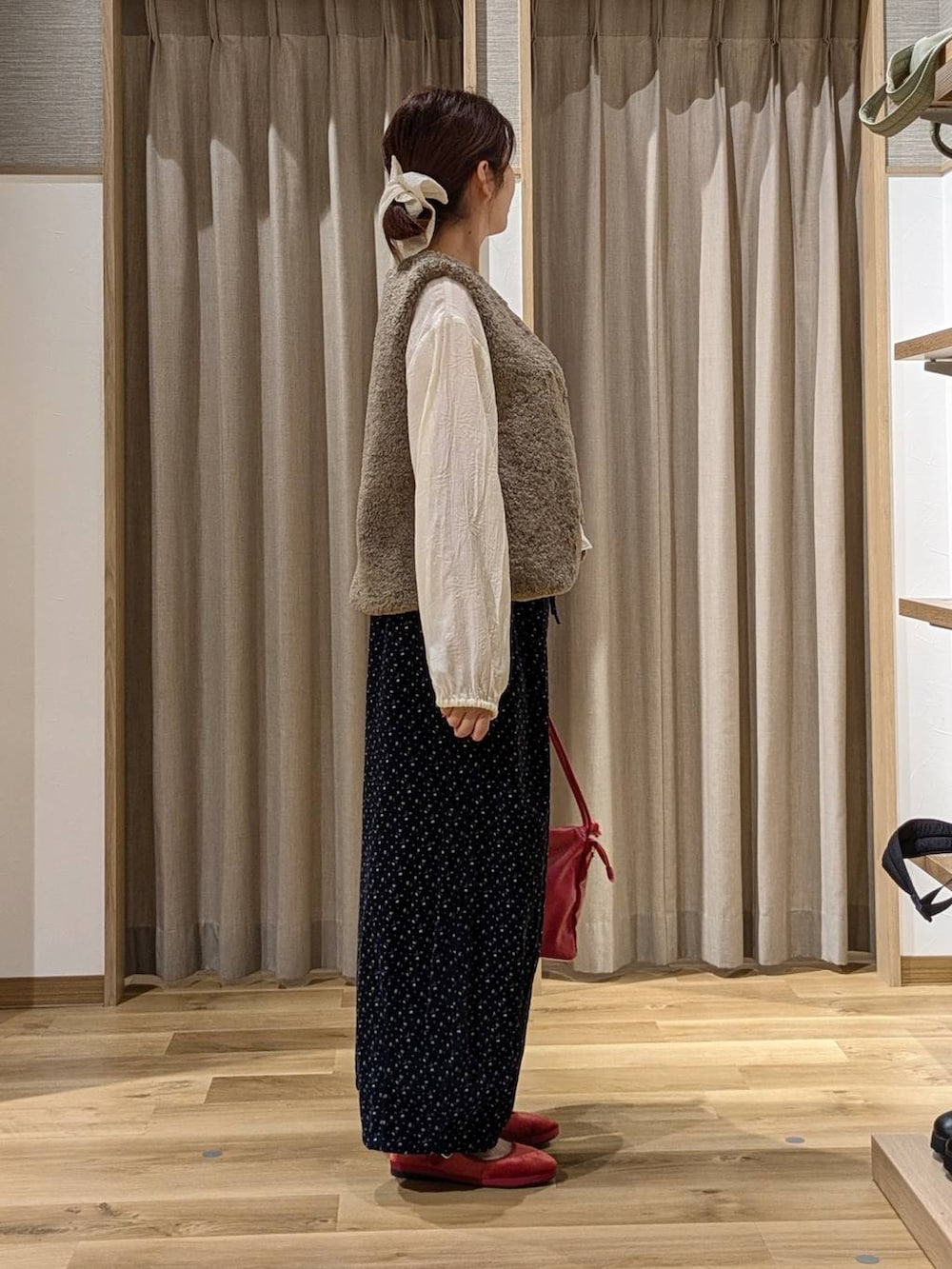 ブルー系のその他パンツ、レッド系のその他シューズ、レッド系のショルダーバッグを着用したレディースの秋コーディネートの2枚目の写真