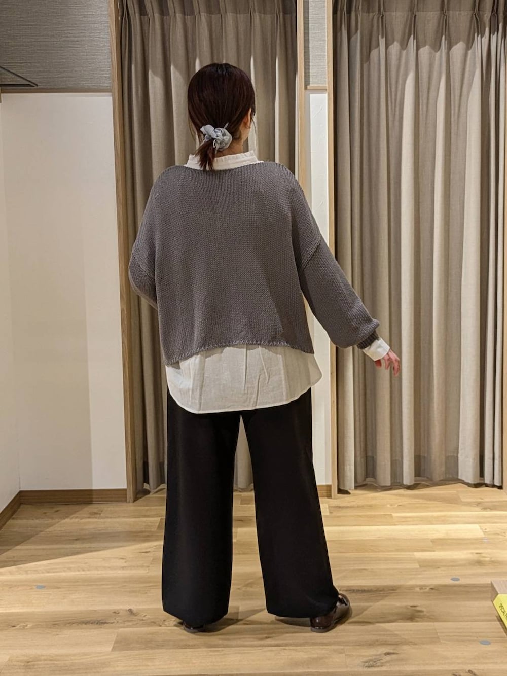 ブラック系のスラックス、ブラウン系のショルダーバッグ、ホワイト系のシャツ/ブラウスを着用したレディースの春コーディネートの2枚目の写真