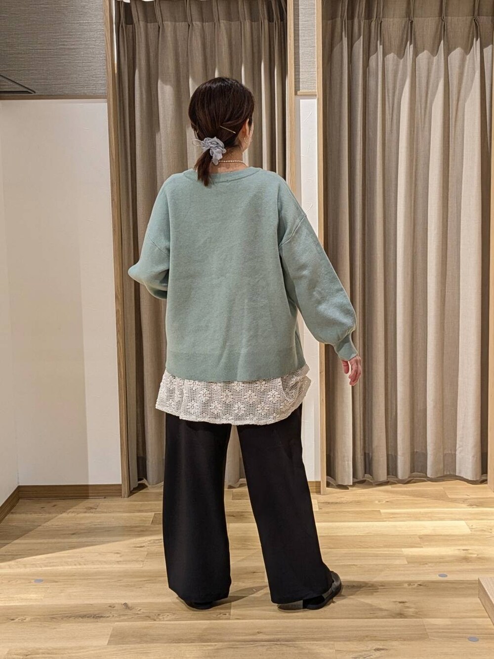 ブラック系のスラックス、ブラック系のショルダーバッグ、ブラック系のスニーカーを着用したレディースの冬コーディネートの2枚目の写真