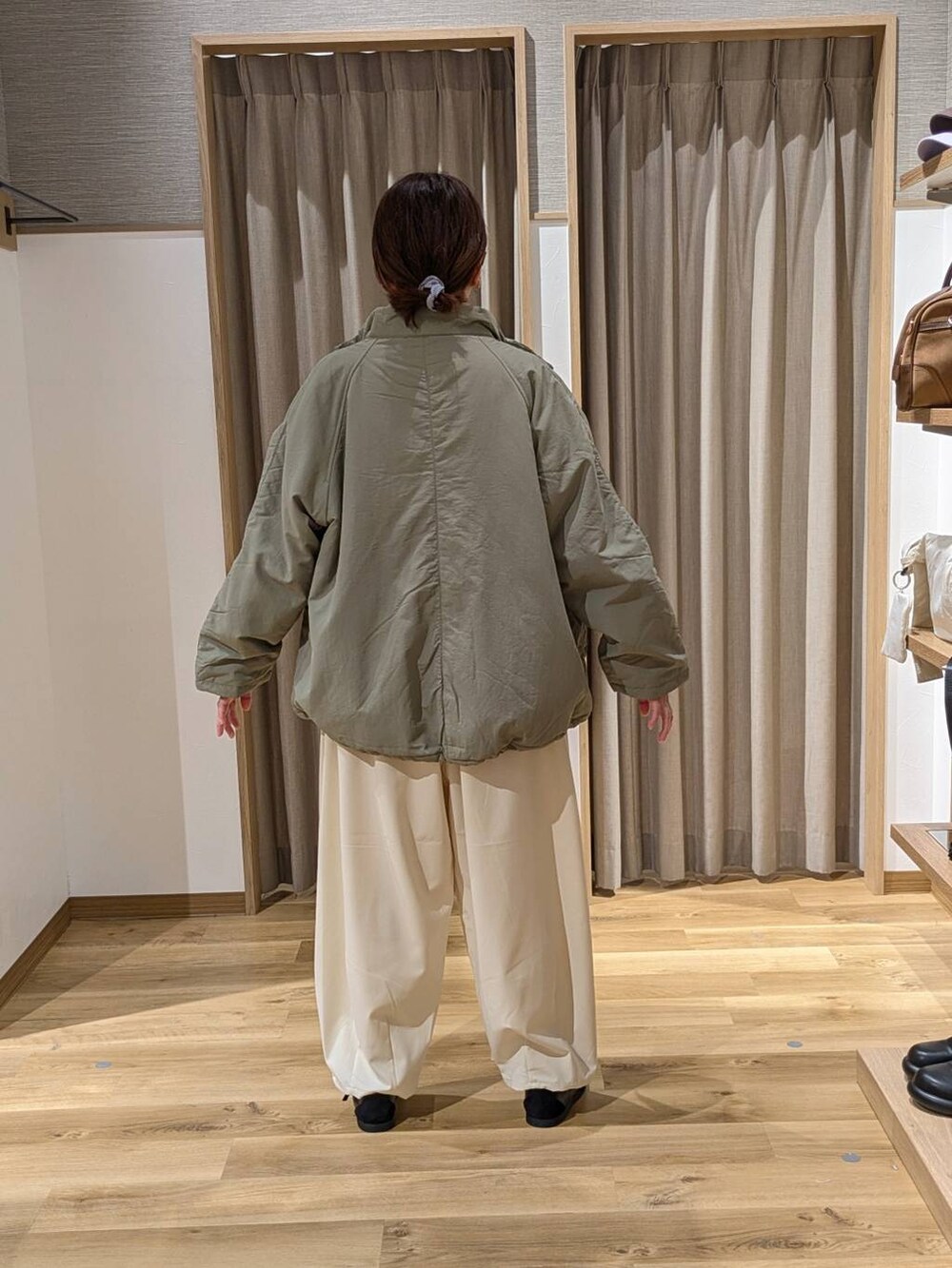 グリーン系のその他アウター、ホワイト系のニット/セーター、ベージュ系のその他パンツを着用したレディースの冬コーディネートの3枚目の写真