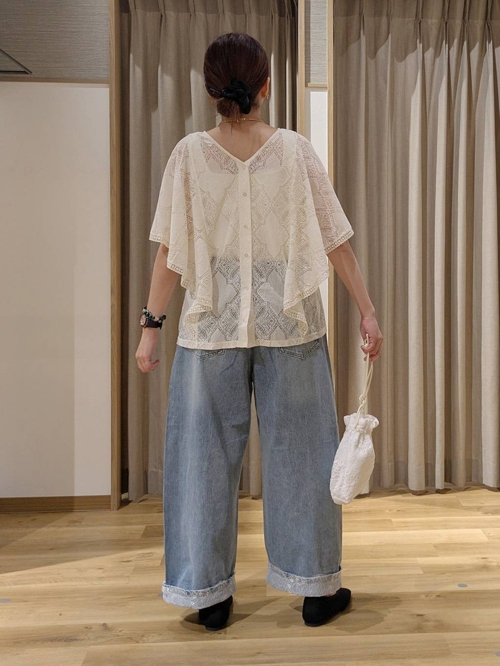 ブルー系のデニムパンツ、ベージュ系のシャツ/ブラウス、ブラック系のパンプスを着用したレディースの秋コーディネートの3枚目の写真