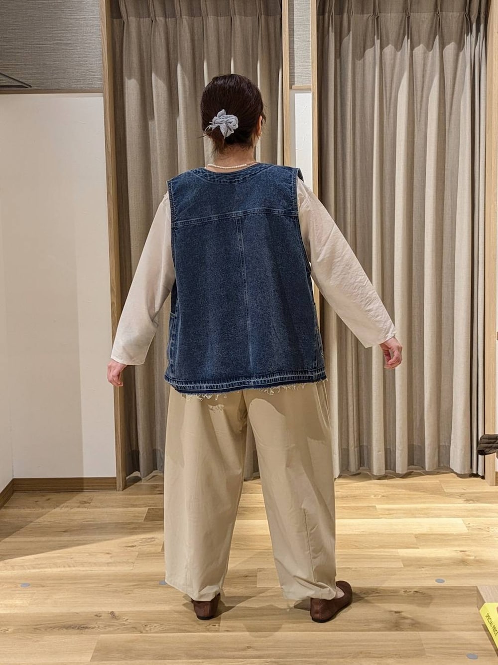 ブルー系のベスト、ベージュ系のその他パンツ、ホワイト系のシャツ/ブラウスを着用したレディースの春コーディネートの2枚目の写真