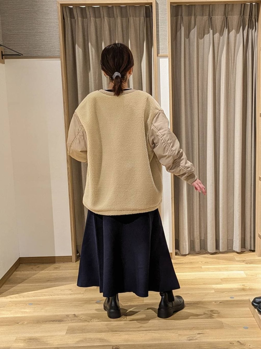 ベージュ系のその他アウター、ブラック系のブーツ、ブルー系のニット/セーターを着用したレディースの冬コーディネートの2枚目の写真