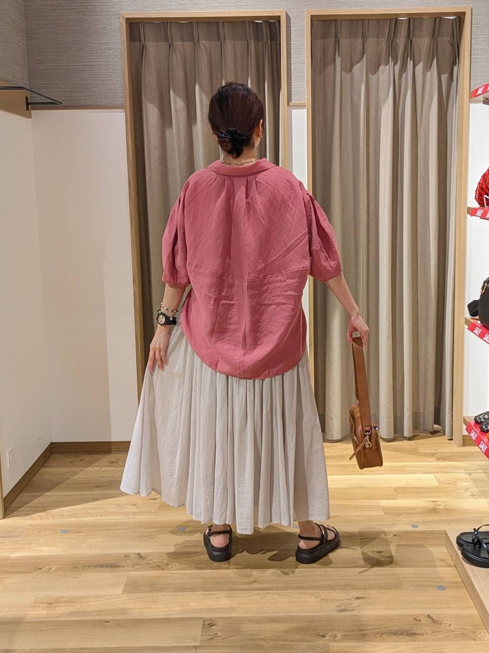 ブラウン系のショルダーバッグ、ブラウン系のサンダル、ピンク系のシャツ/ブラウスを着用したレディースの夏コーディネートの2枚目の写真