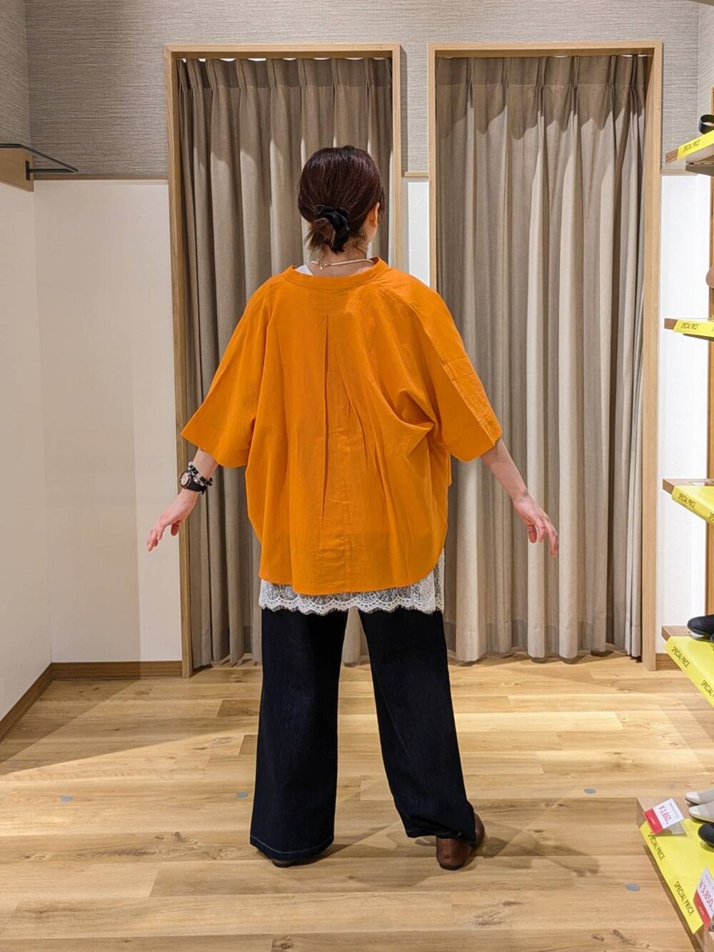 ブラウン系のショルダーバッグ、ブラウン系のパンプス、ブルー系のデニムパンツを着用したレディースの春コーディネートの2枚目の写真
