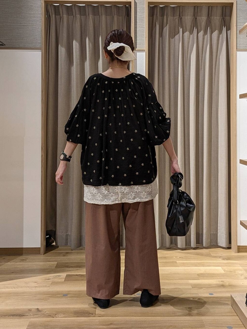 ブラック系のシャツ/ブラウス、ホワイト系のベスト、ブラック系のトートバッグを着用したレディースの夏コーディネートの3枚目の写真