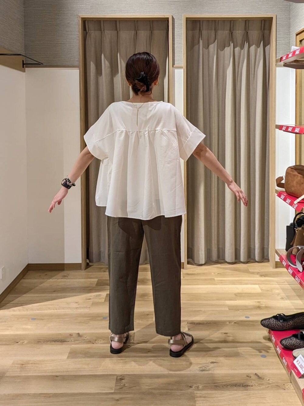 ブラック系のトートバッグ、ゴールド系のサンダル、グリーン系のその他パンツを着用したレディースの夏コーディネートの2枚目の写真