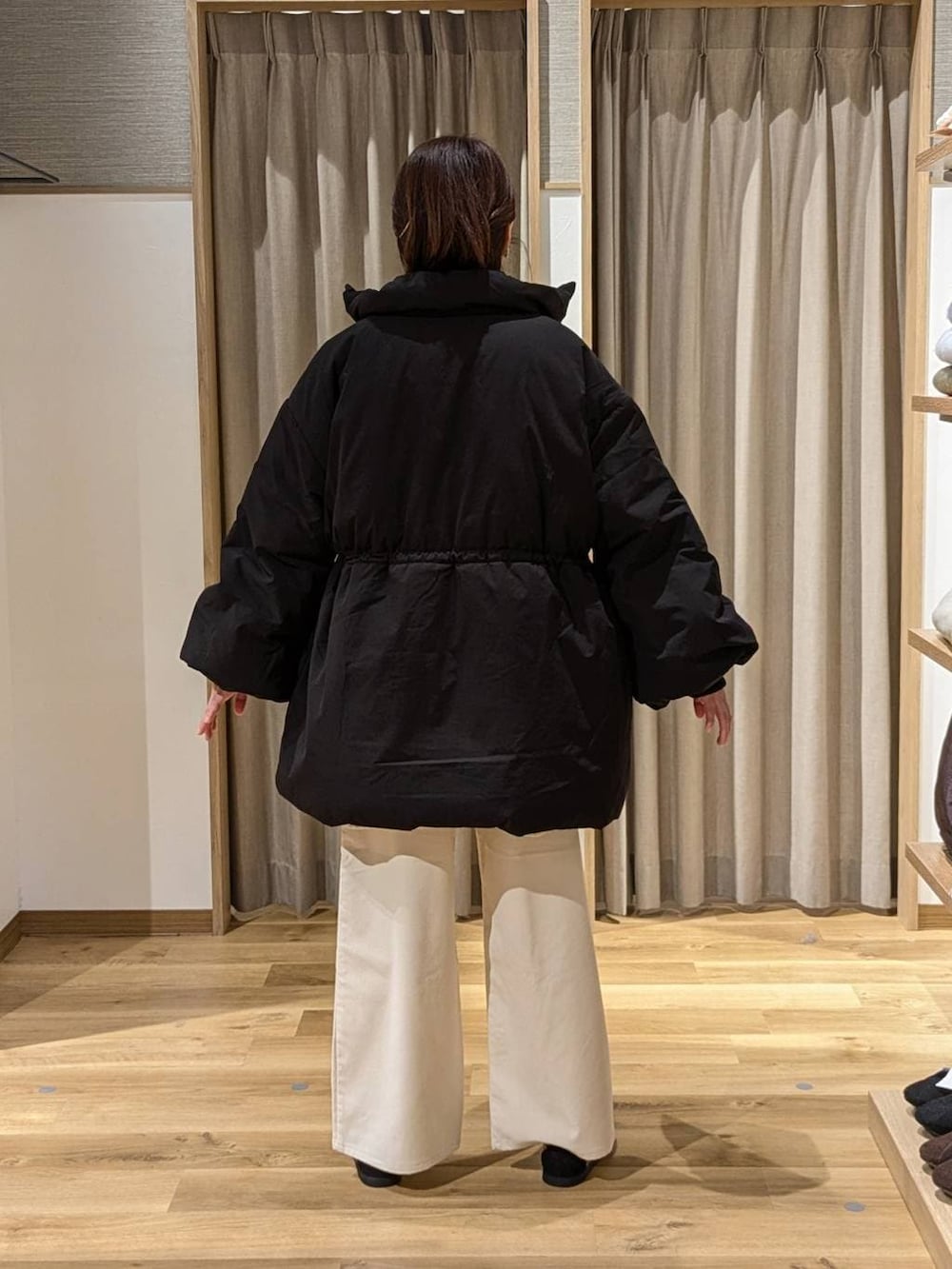 ブラック系のダウンジャケット/コート、ベージュ系のその他パンツ、その他のスニーカーを着用したレディースの冬コーディネートの2枚目の写真