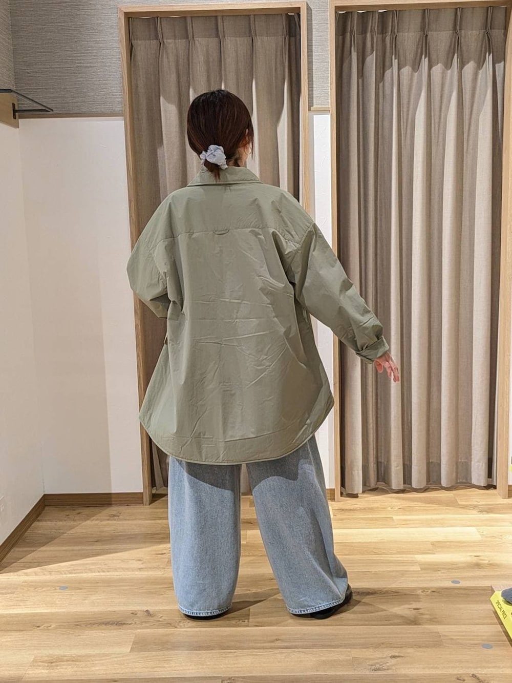 グリーン系のその他アウター、ブラック系のスニーカー、ブルー系のデニムパンツを着用したレディースの冬コーディネートの3枚目の写真