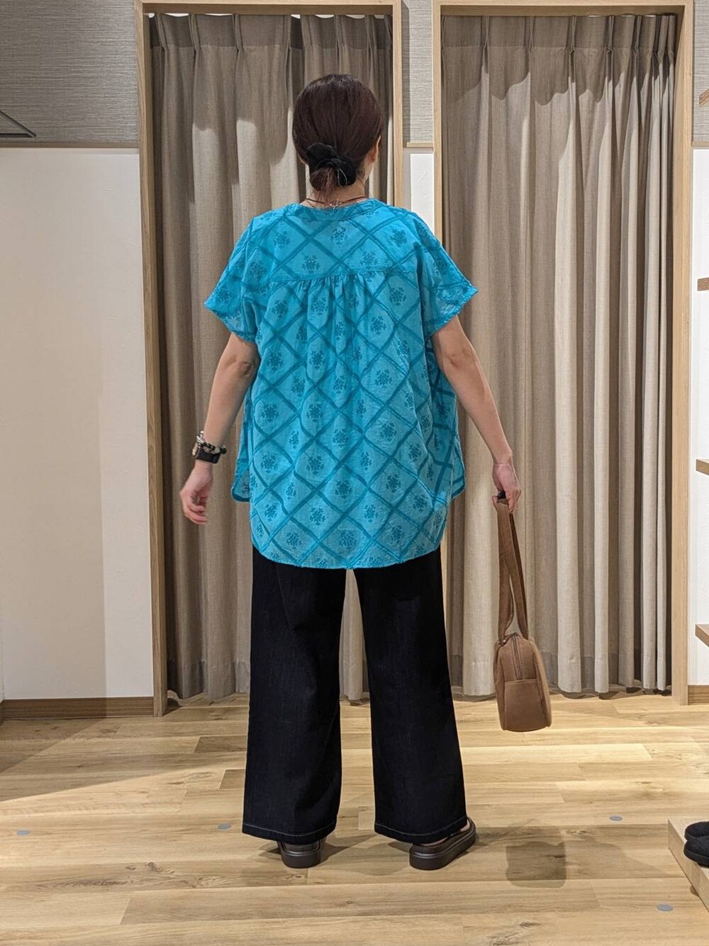 ブラウン系のショルダーバッグ、ブラウン系のサンダル、ブラウン系のタンクトップを着用したレディースの夏コーディネートの3枚目の写真
