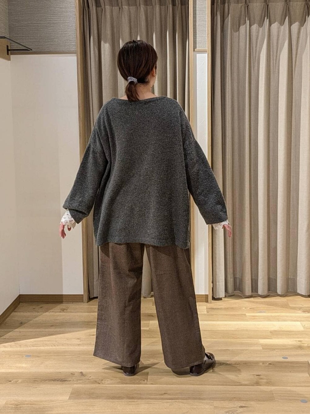 ブラウン系のその他パンツ、グレー系のその他トップス、ブラック系のショルダーバッグを着用したレディースの冬コーディネートの2枚目の写真