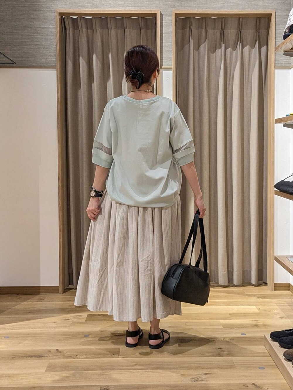 ブラック系のショルダーバッグ、グリーン系のTシャツ/カットソー、その他のスカートを着用したレディースの夏コーディネートの3枚目の写真