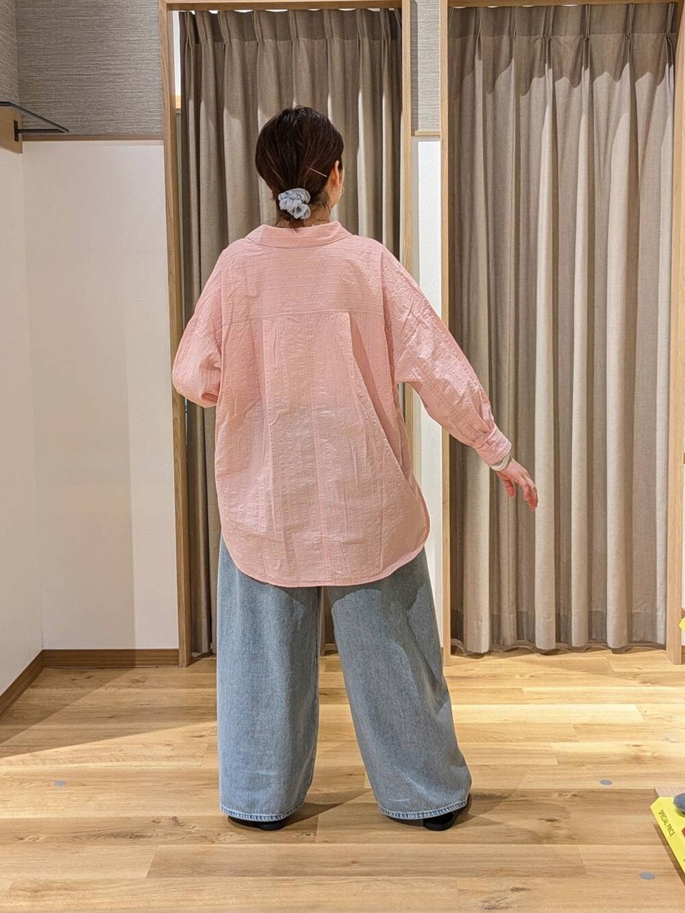 ブルー系のデニムパンツ、ブラック系のスニーカー、ブラック系のショルダーバッグを着用したレディースの冬コーディネートの2枚目の写真