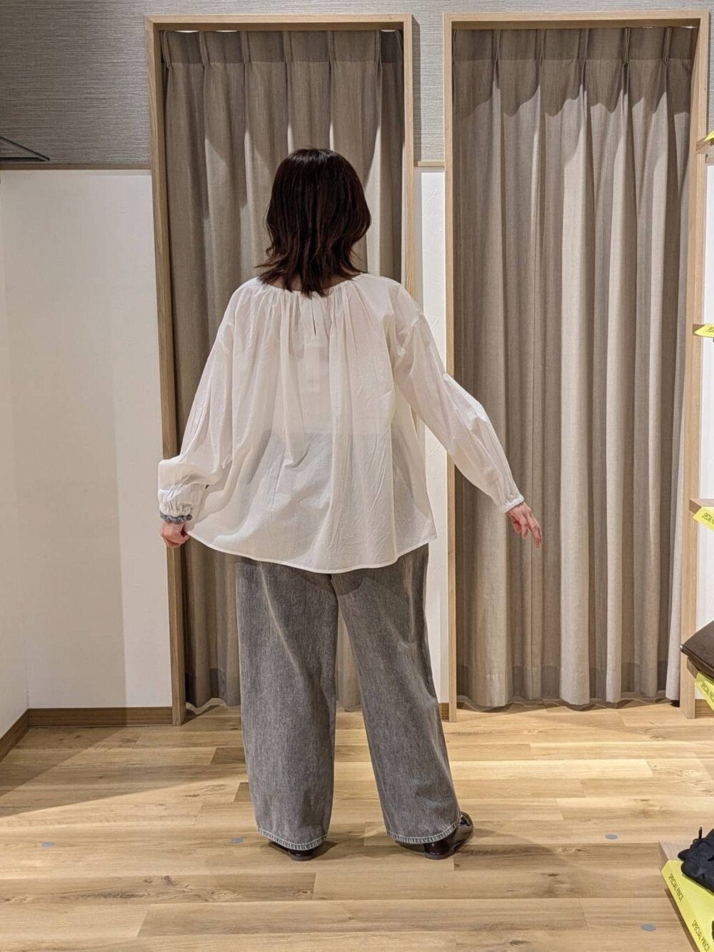 グレー系のデニムパンツ、ブラウン系のトートバッグ、ブラウン系のローファーを着用したレディースの春コーディネートの2枚目の写真