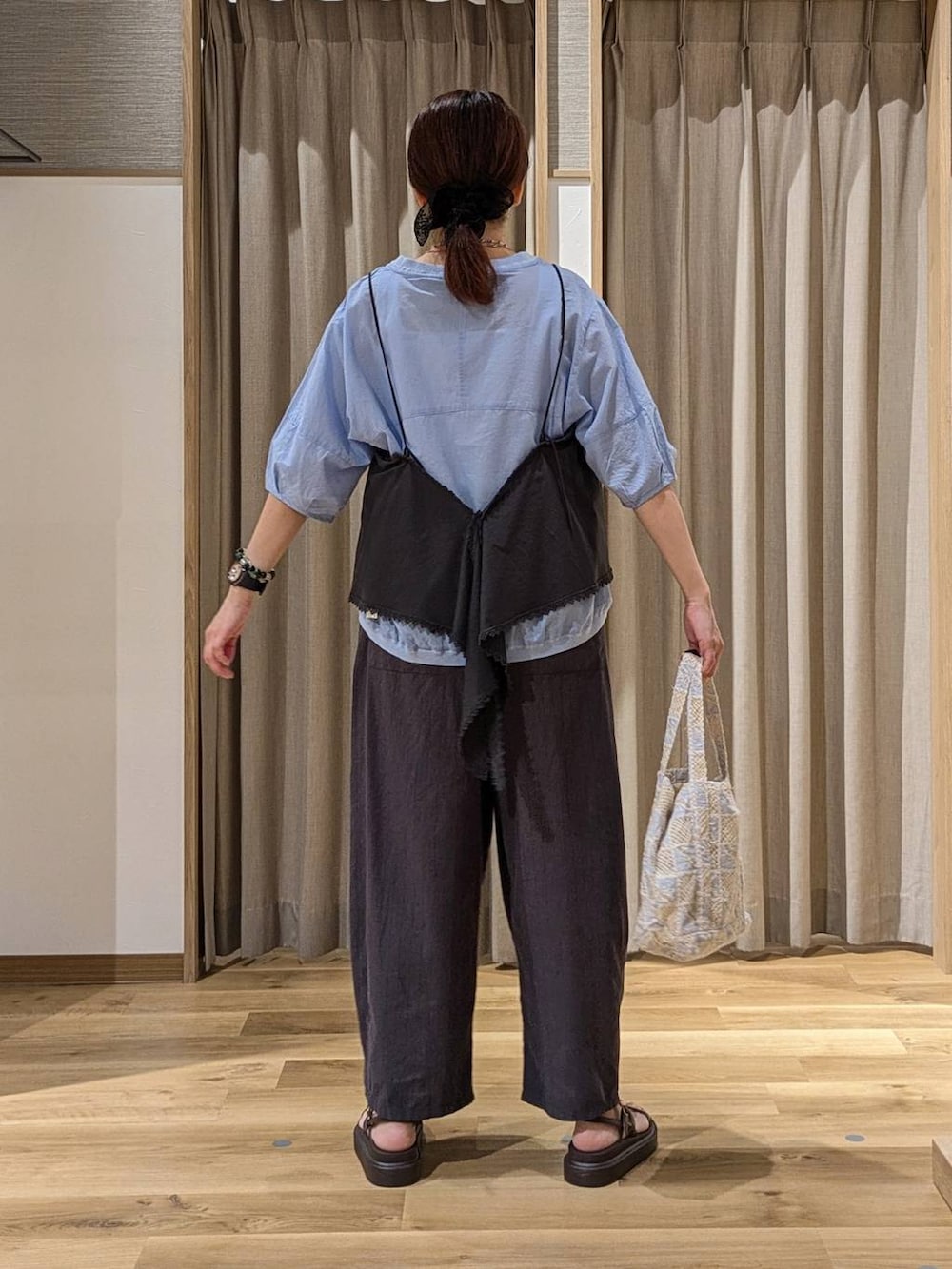 グレー系のキャミソール、ブルー系のシャツ/ブラウス、ブラウン系のサンダルを着用したレディースの夏コーディネートの3枚目の写真